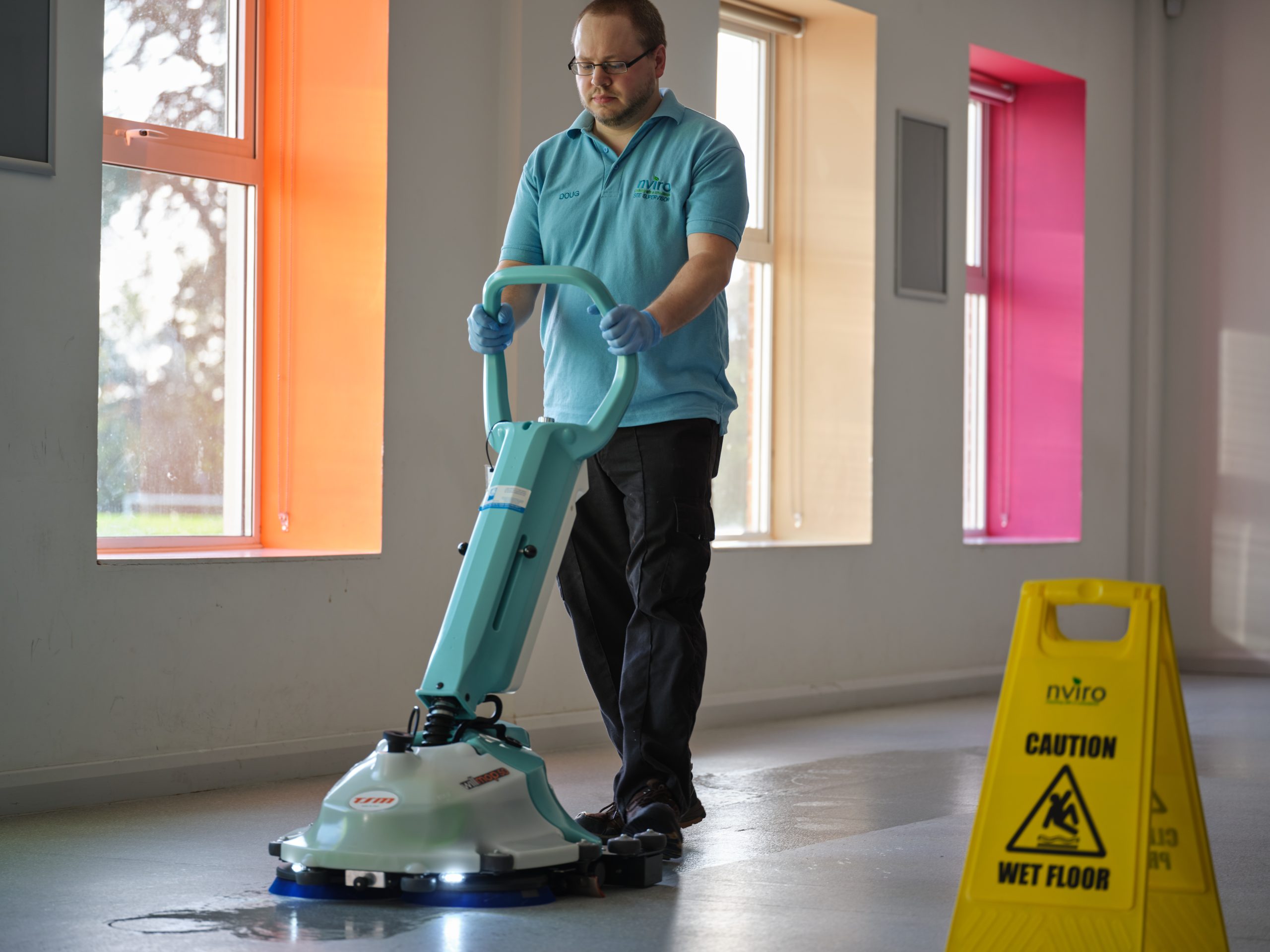 Cleaner using scrubber dryer to clean floor on the hard floor